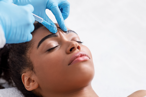Young woman having botox in forehead