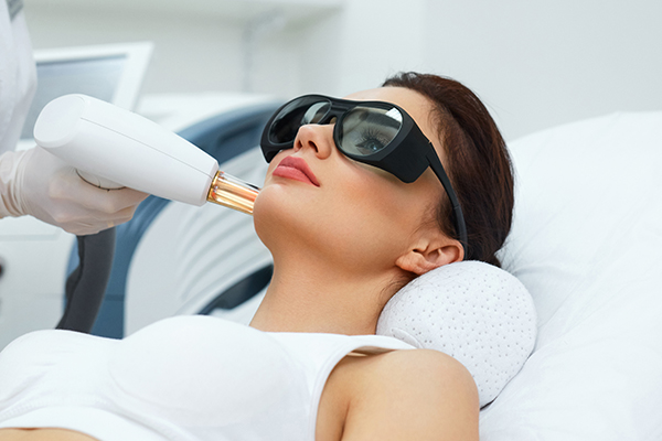 Woman having laser facial treatment