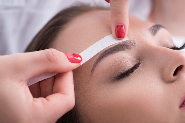 Woman having brows waxed